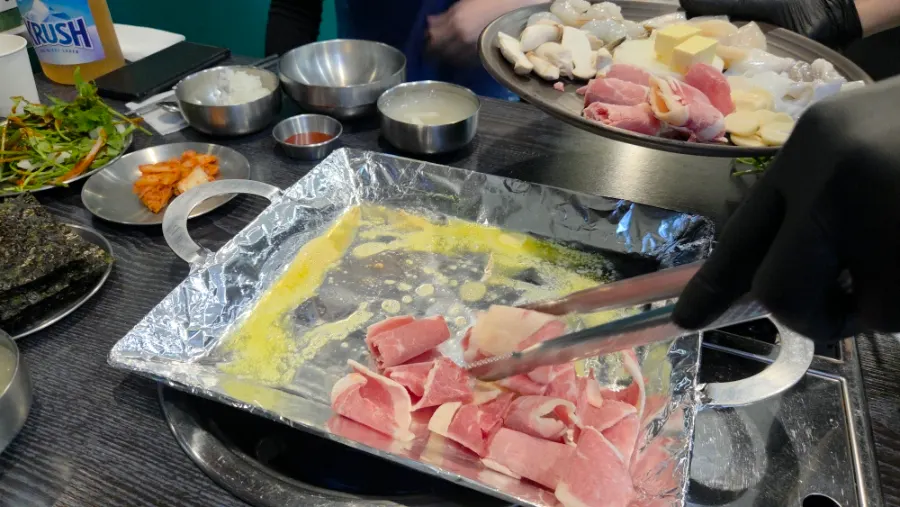 Butter piled on the seafood-and-meat grill set on the hot plate