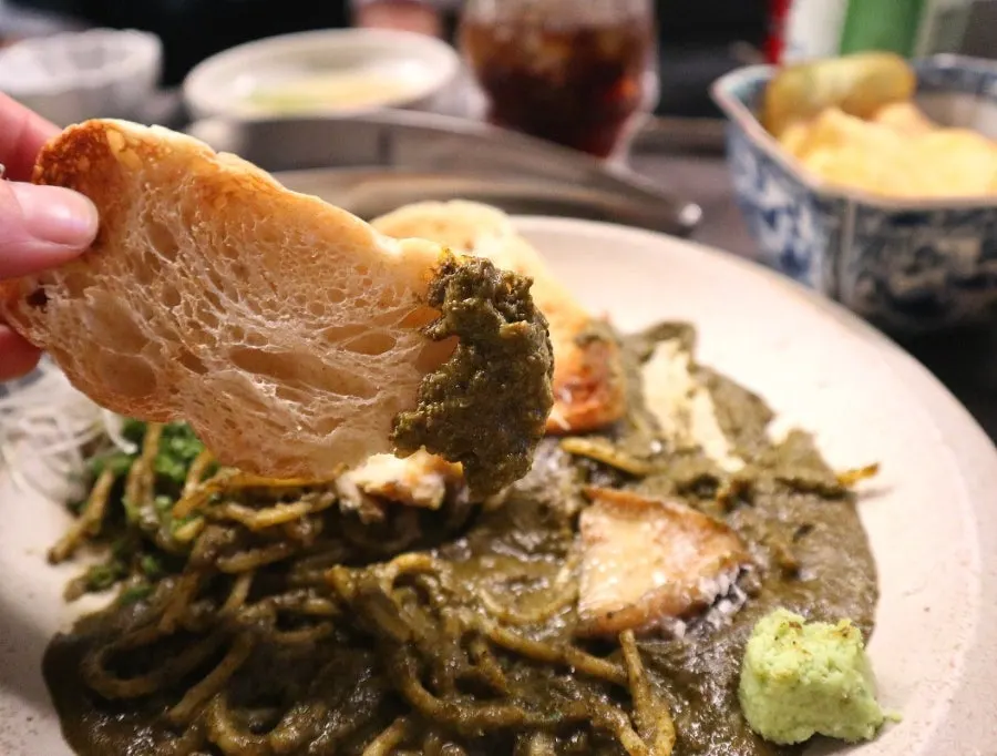 A piece of abalone placed on top of the pasta noodles