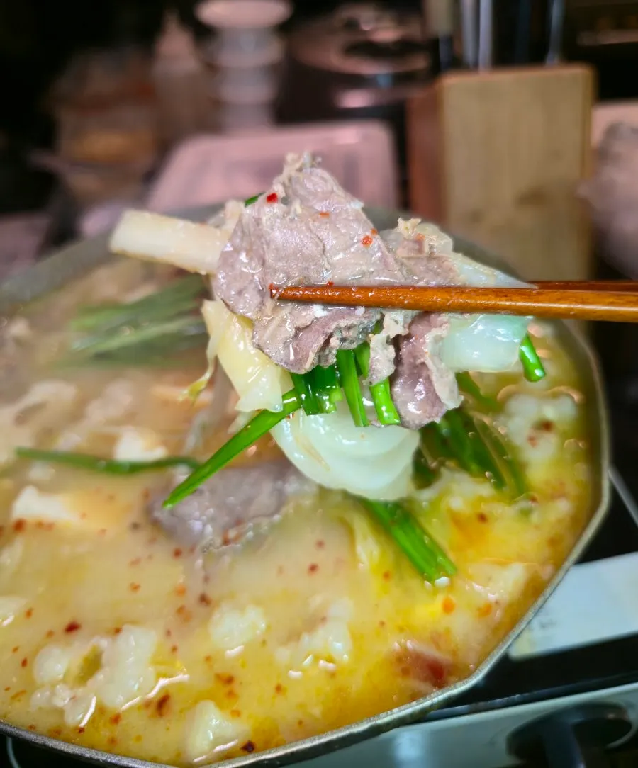 Motsunabe broth with chili flakes and chives