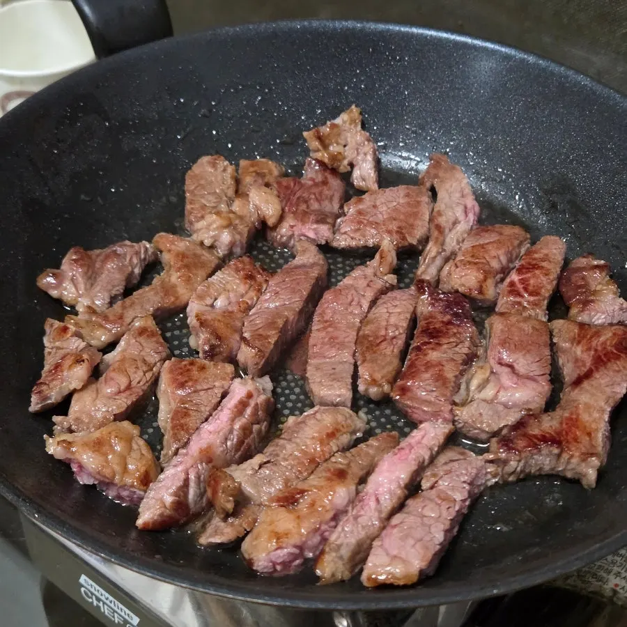 Thick wagyu ribeye grilling on the pan