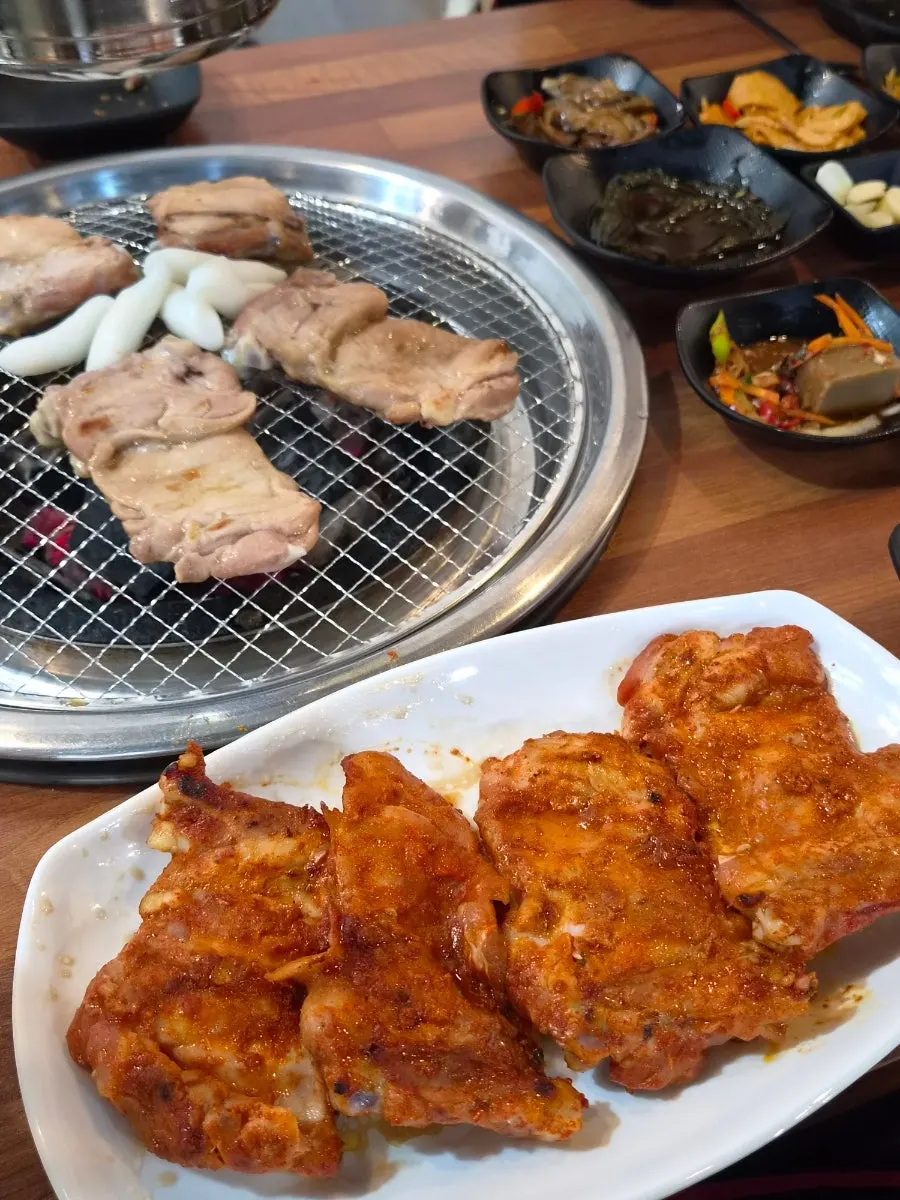 Charcoal grill with both spicy and soy-sauce dakgalbi cooking together