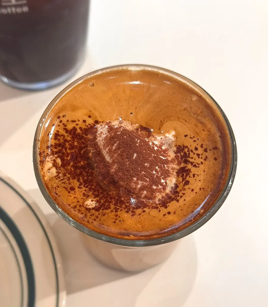 Close-up of the thick cream topping on the signature coffee