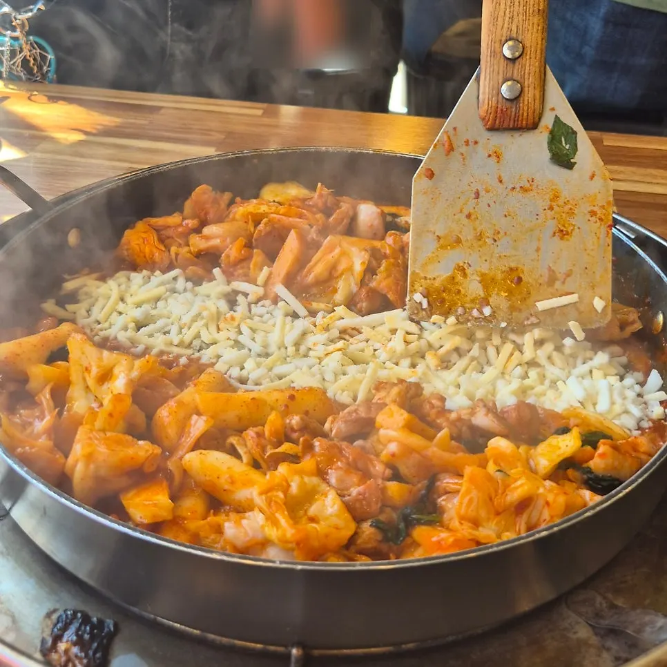 Dipping dakgalbi into the melted cheese
