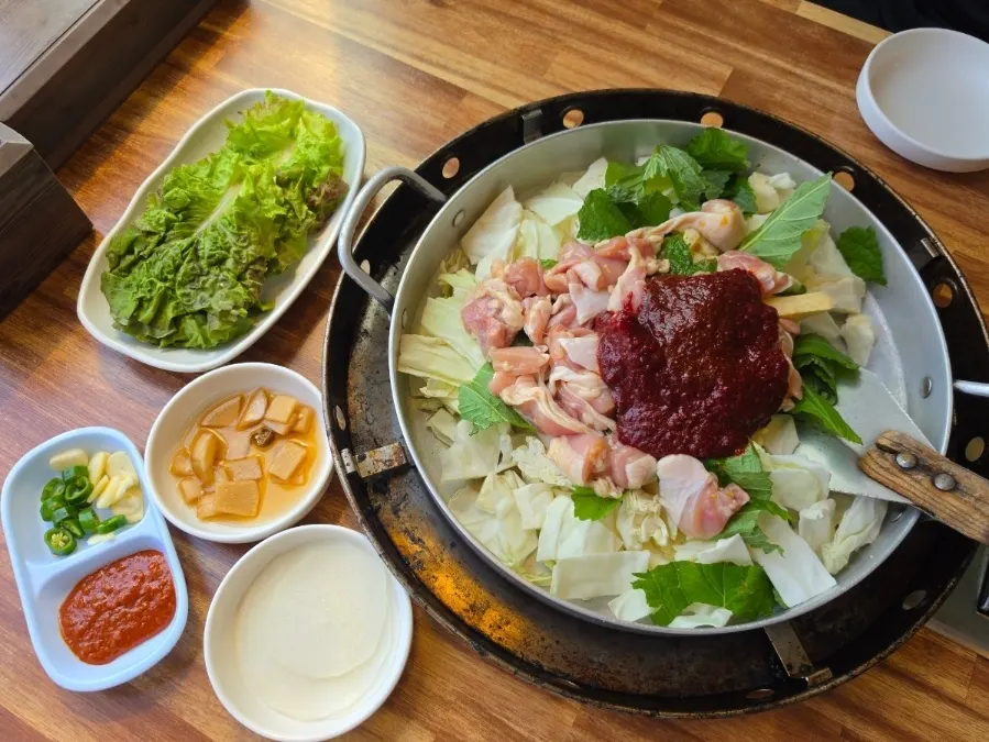 Mesa servida con dakgalbi y guarniciones
