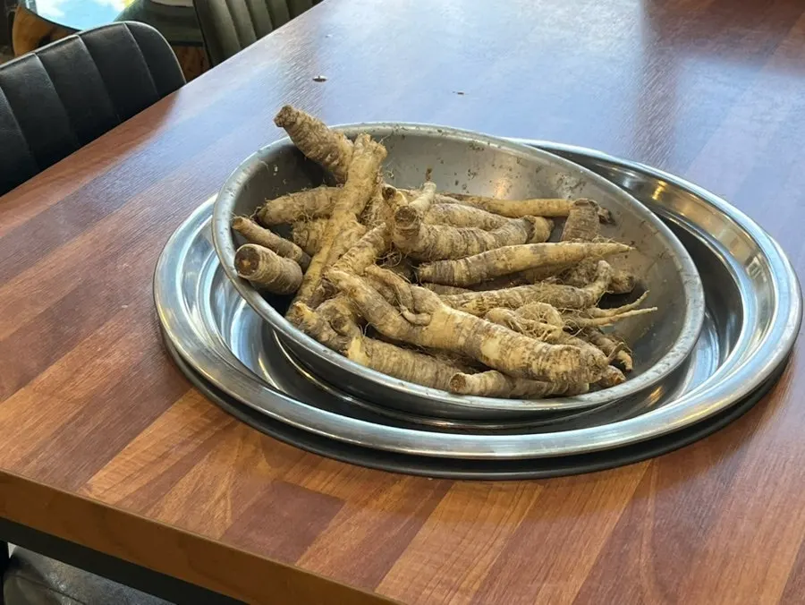 Raw, unprepared deodeok displayed on one side of the restaurant