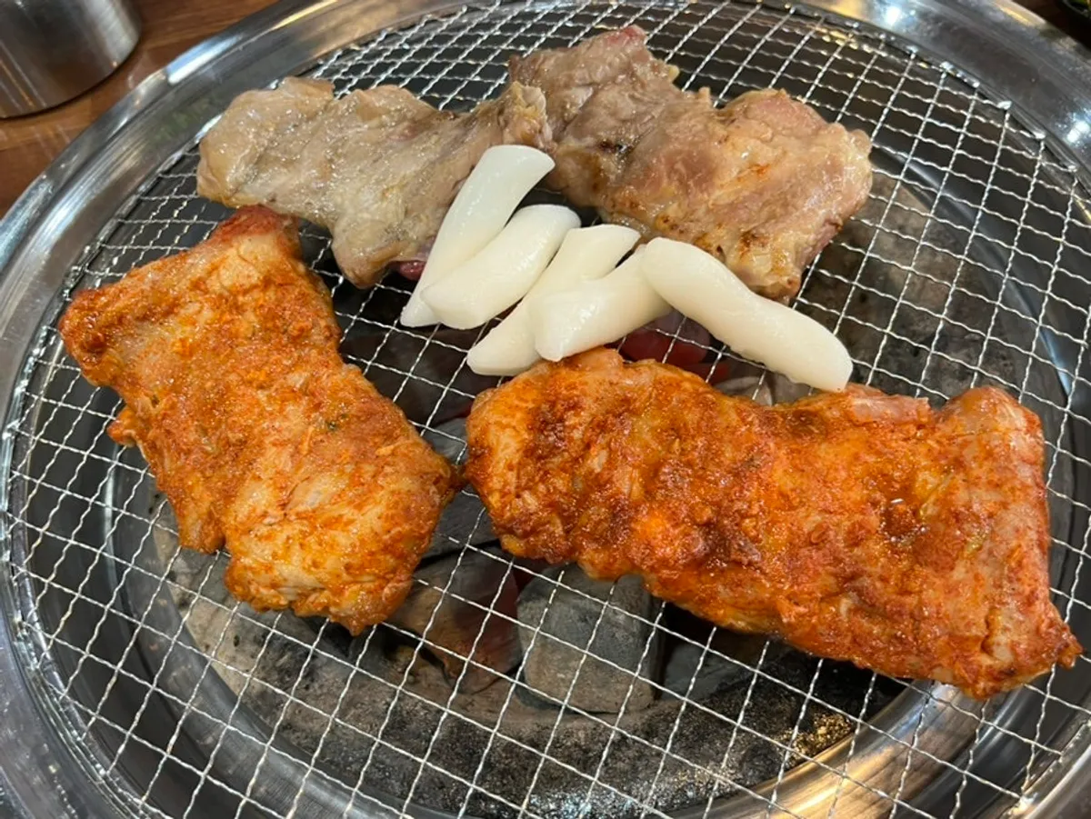 Dakgalbi and rice cake cooking over the charcoal grill