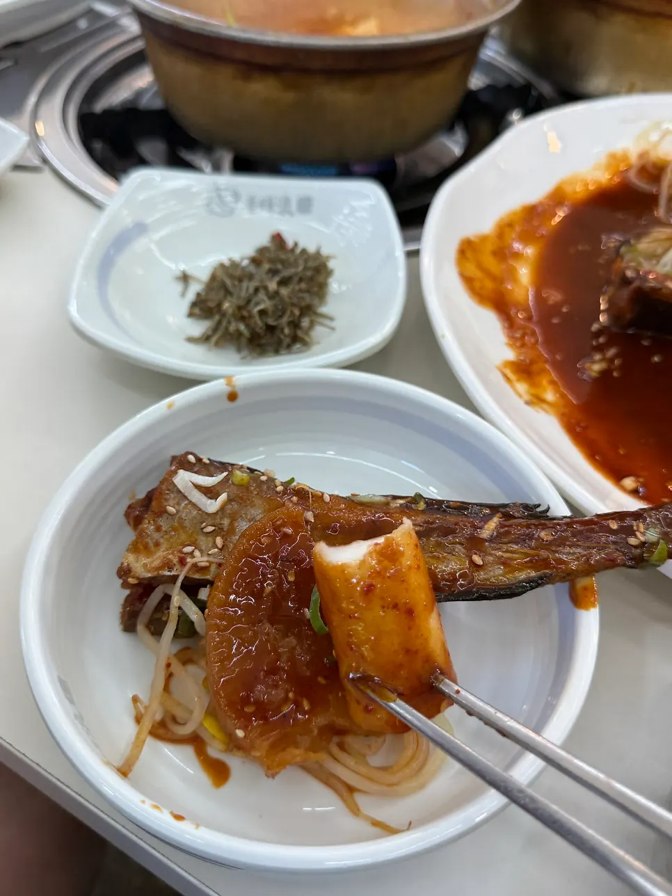 Trozo de dongtae-jeon levantado con los palillos