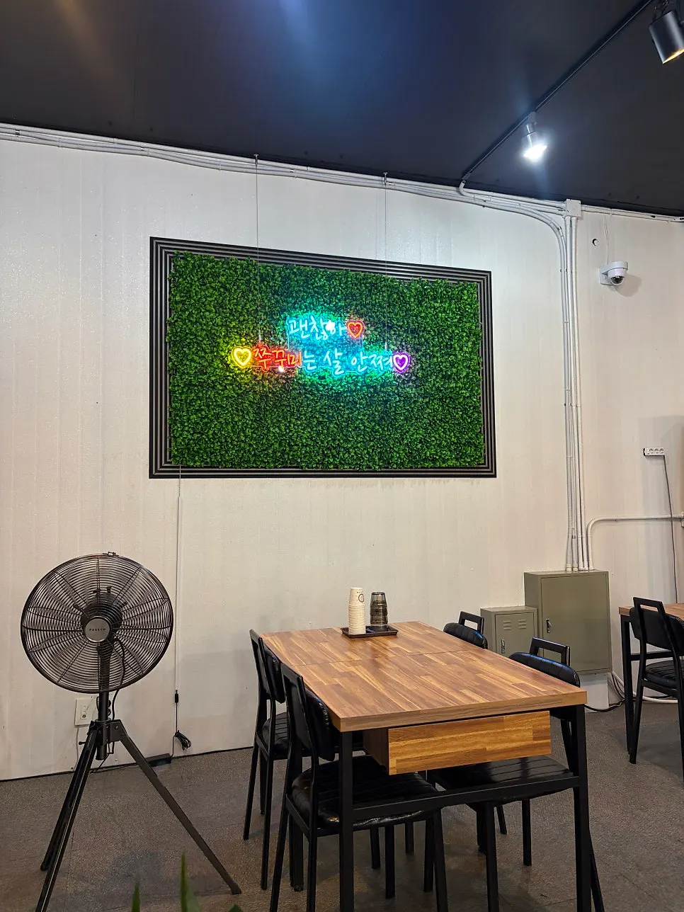 Wall with a neon sign reading 'jjukkumi'