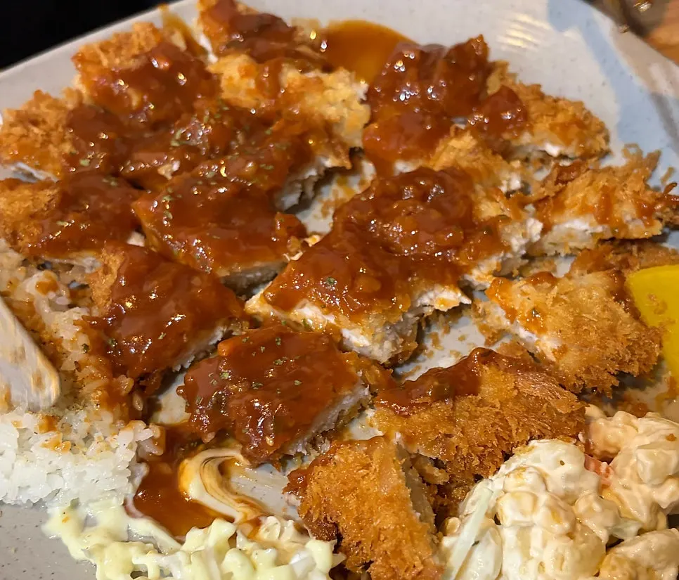 Hand-breaded pork loin cutlet drizzled with sauce