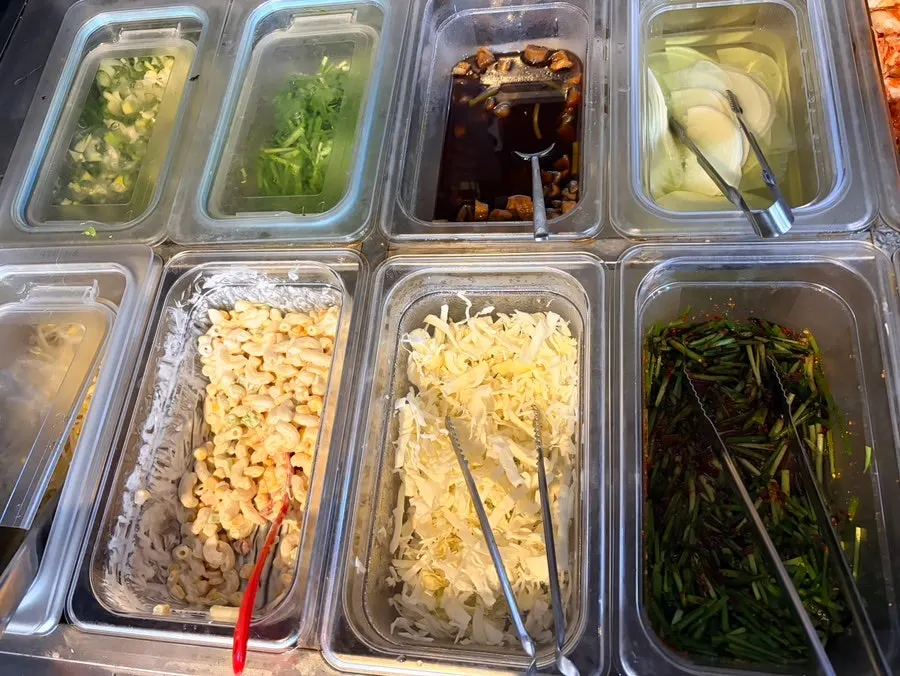 Row of dishes lined up at the self-serve buffet corner