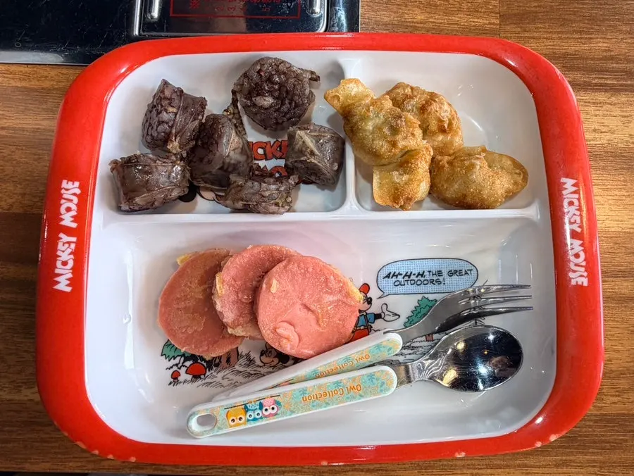 A small plate of snacks set aside for the kids with baby utensil set