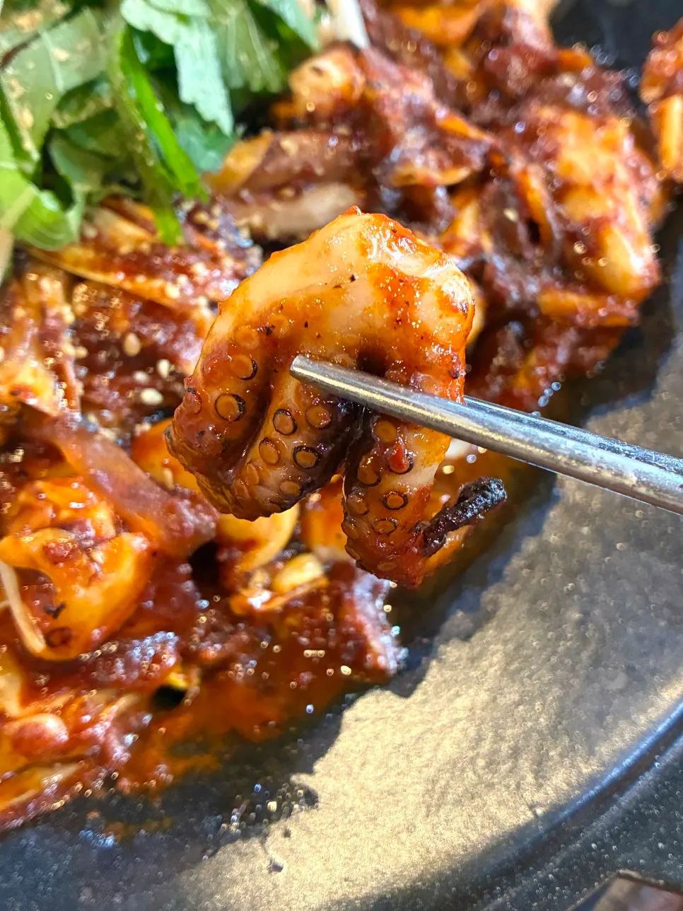 A bite of jjukkumi stir-fry on the griddle