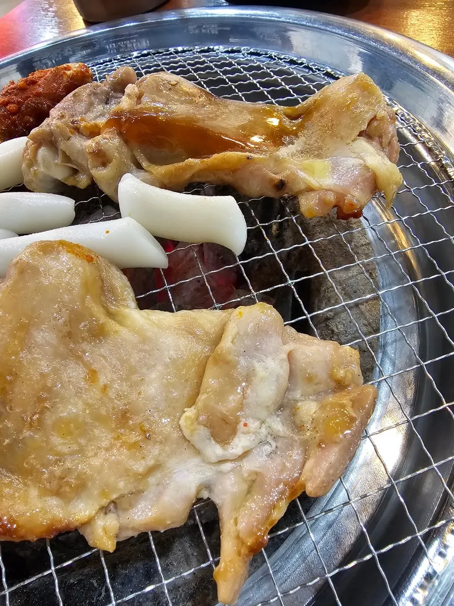 A bite of charcoal dakgalbi paired with deodeok-muchim