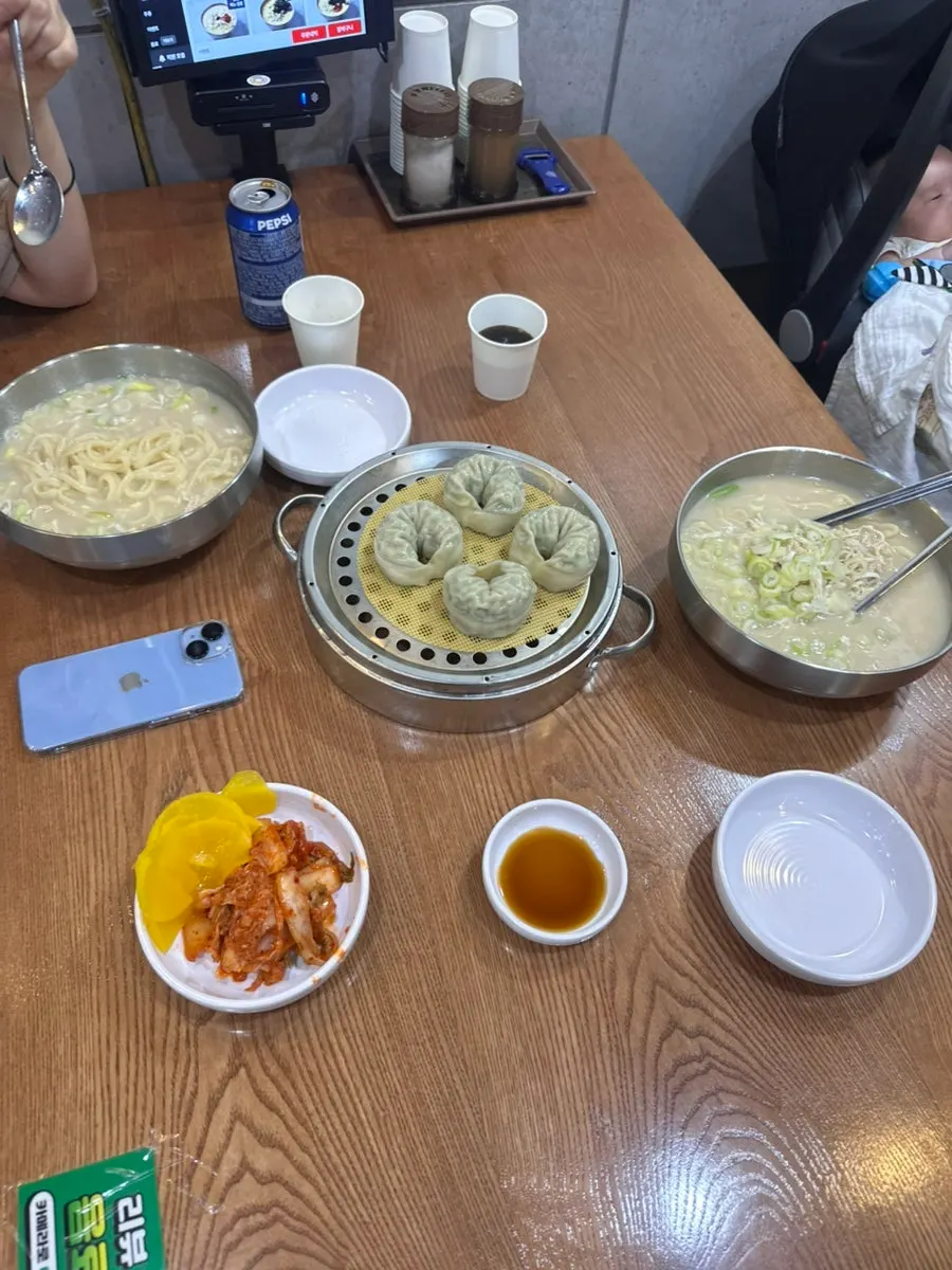 A bowl of dak kalguksu topped with chicken and scallions