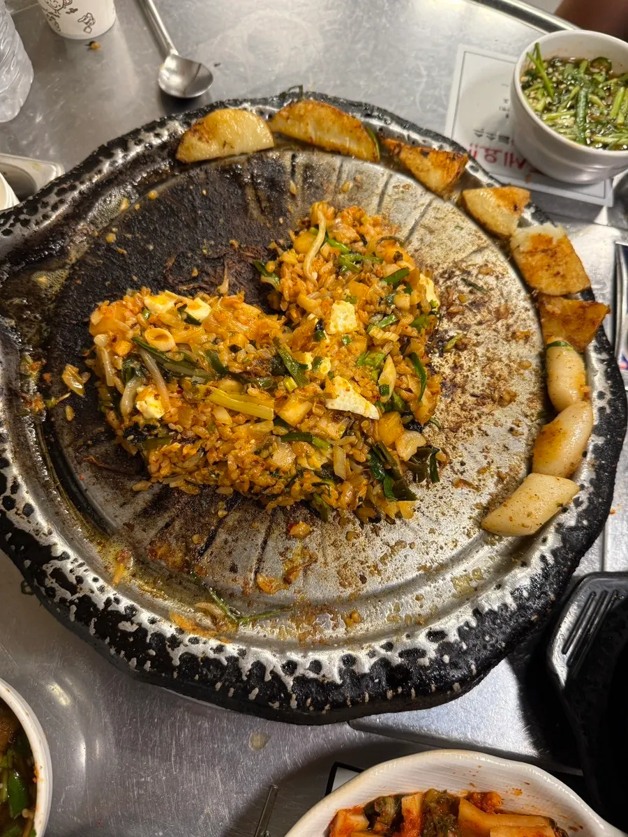A bite of gopchang wrapped with vegetables