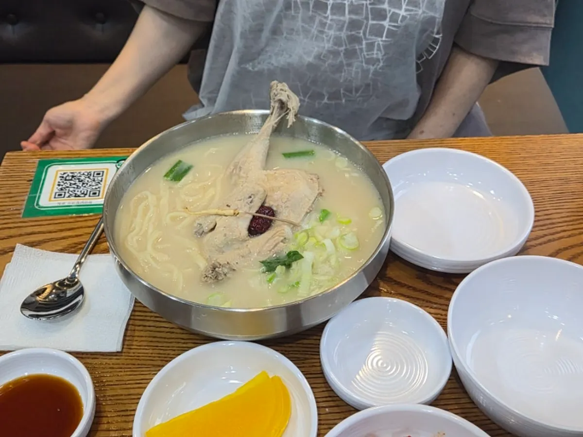 A bowl of samgyetang kalguksu with half a chicken