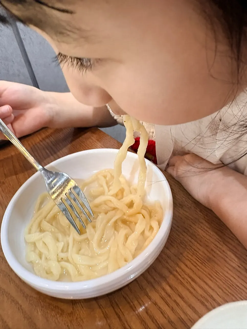 Bowl of chicken noodle soup shared with a child