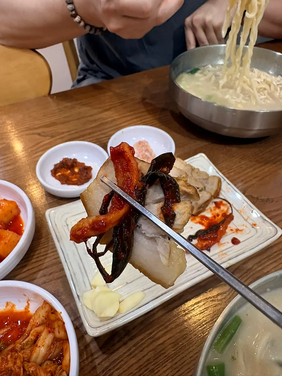 Suyuk topped with garlic, chili, and dried radish strips
