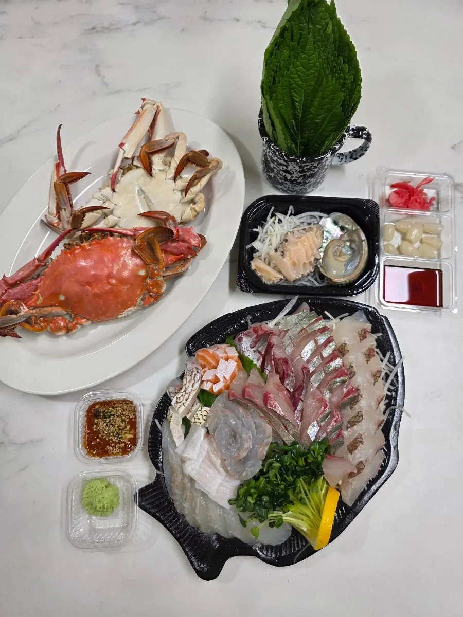 Home spread with sashimi, steamed crab, and stew