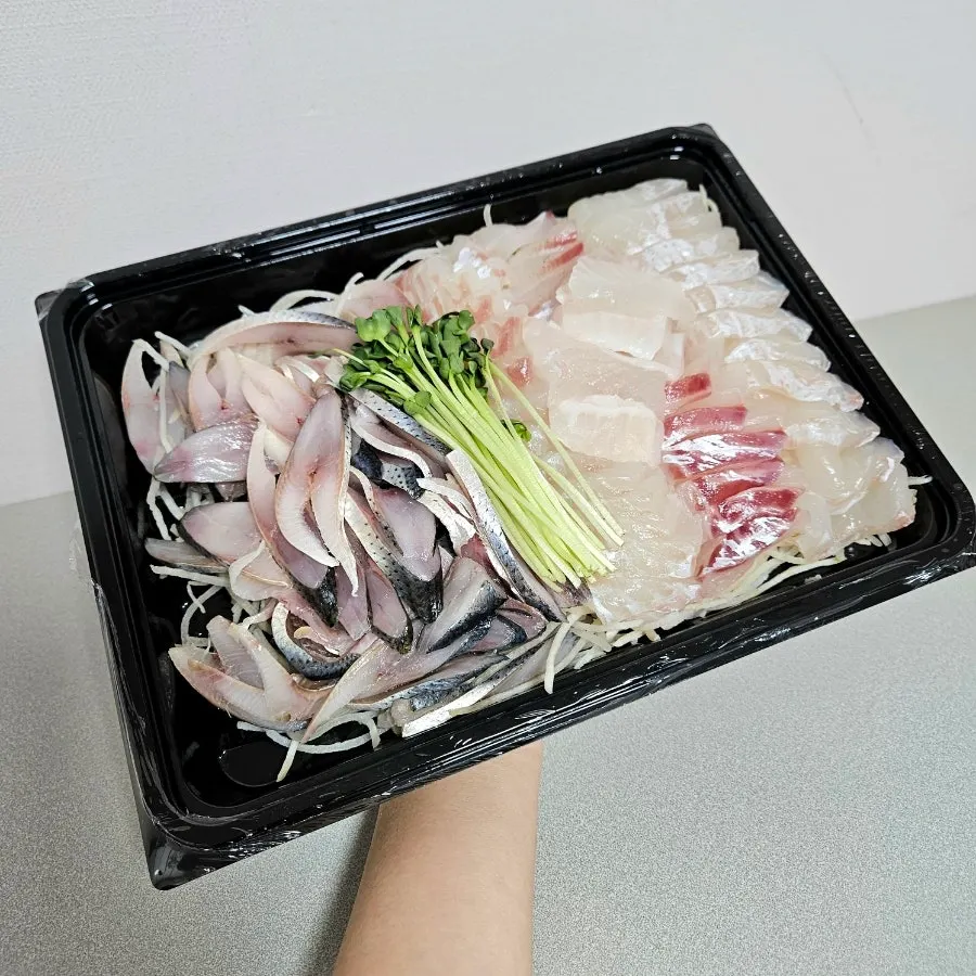 Plate of sashimi given a second layer of plastic wrap