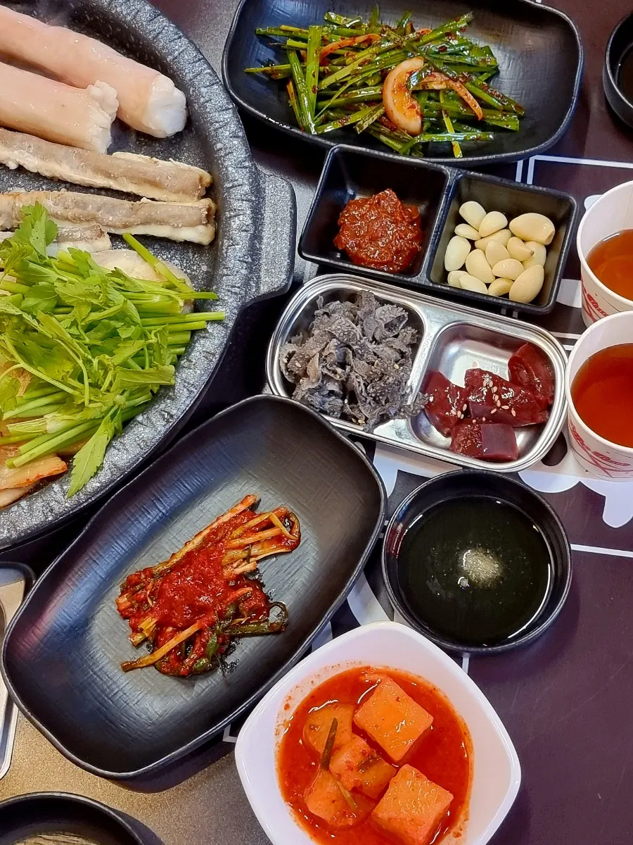 Spread of basic side dishes like green onion kimchi and kkakdugi