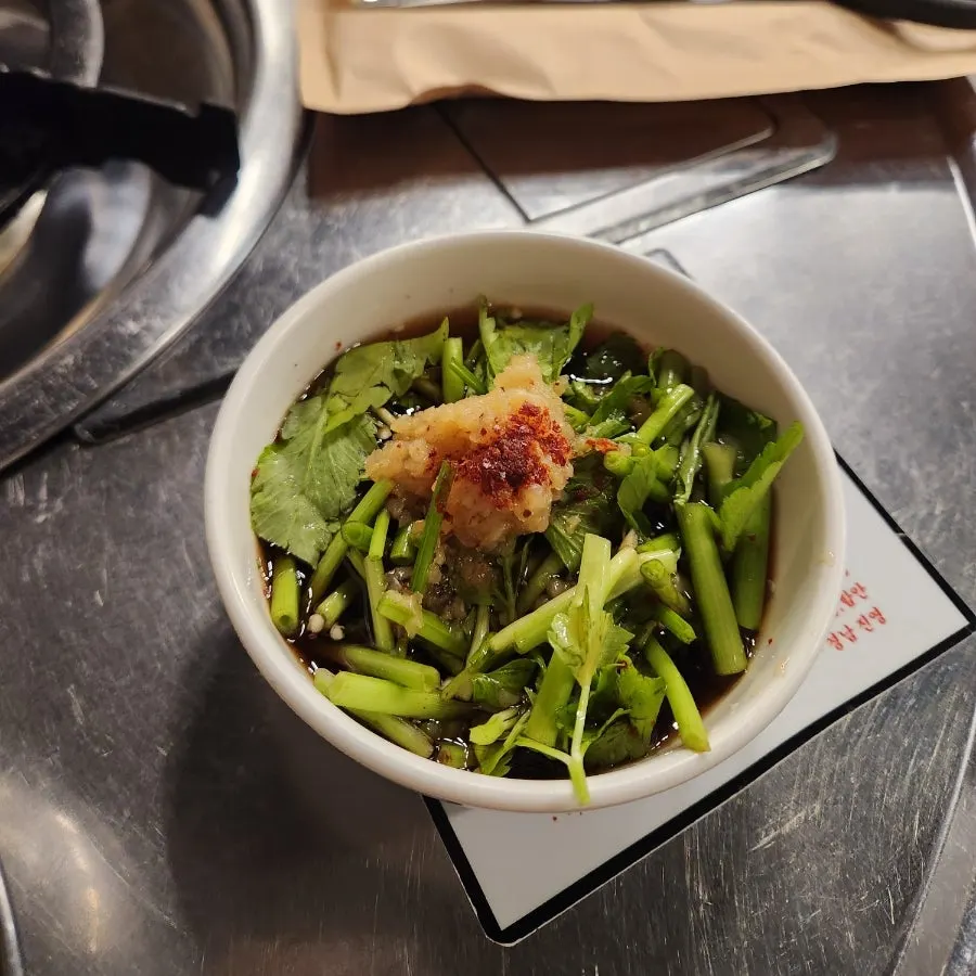 A bowl of minari-pickled garlic sauce