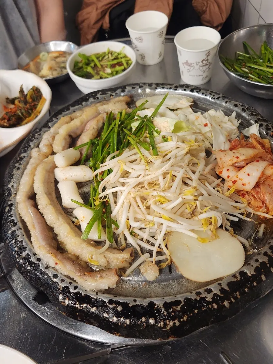 Gopchang grilling with chives and green onion kimchi on top