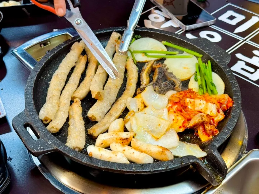 Gopchang, tteok, dan bawang bombay yang sedang dibakar