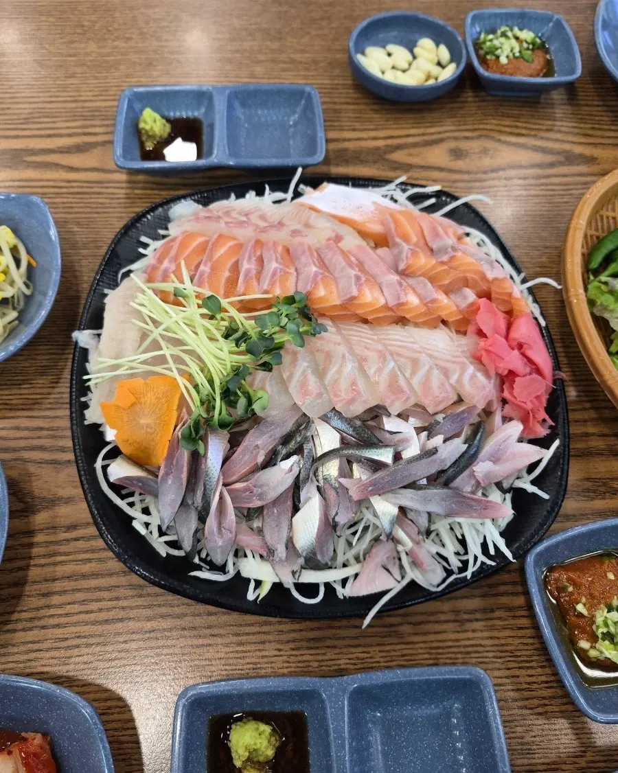 Vertical photo of gizzard shad sashimi table at Yeongjae Susan, Garak Market