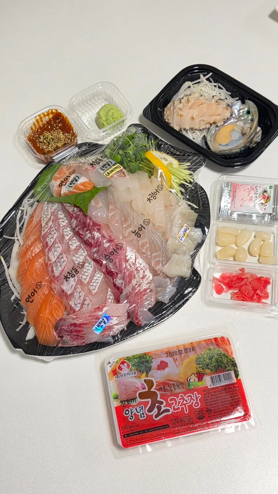 Free abalone sashimi served with chojang, ssamjang and wasabi