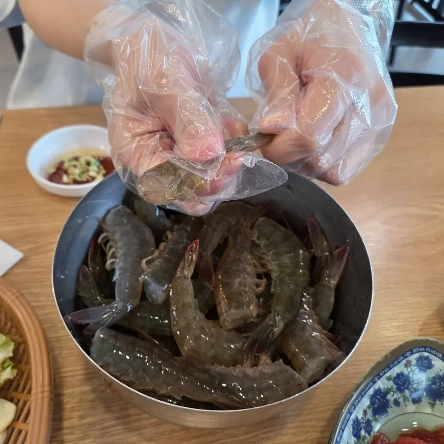 A chaotic table scene of peeling live shrimp