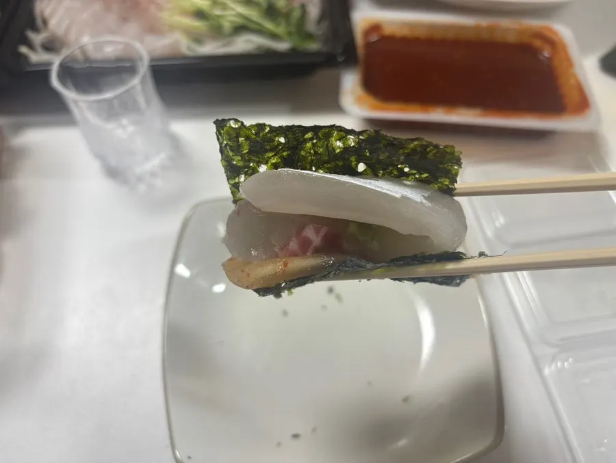 Sashimi topped with aged kimchi on gimchori kim