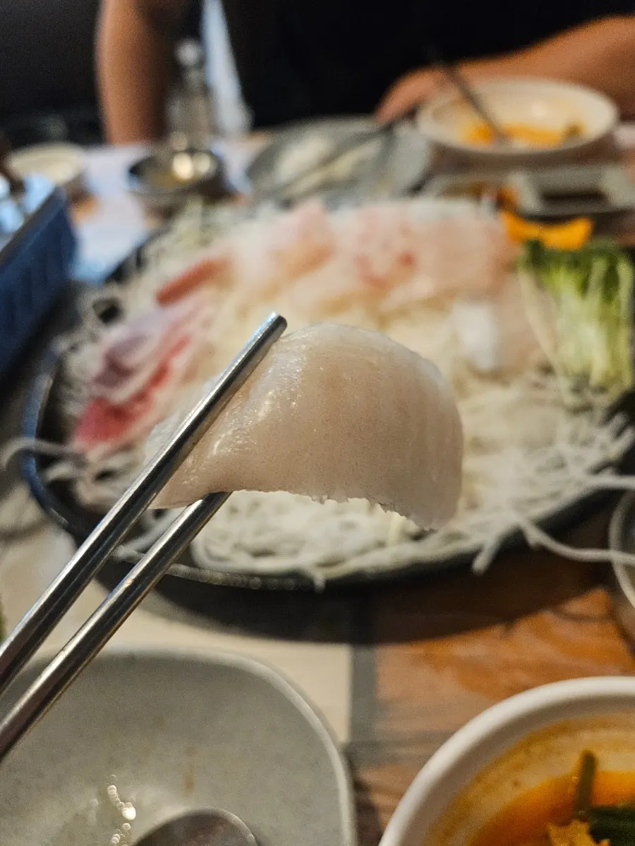 Sashimi dipped in soy sauce and wasabi