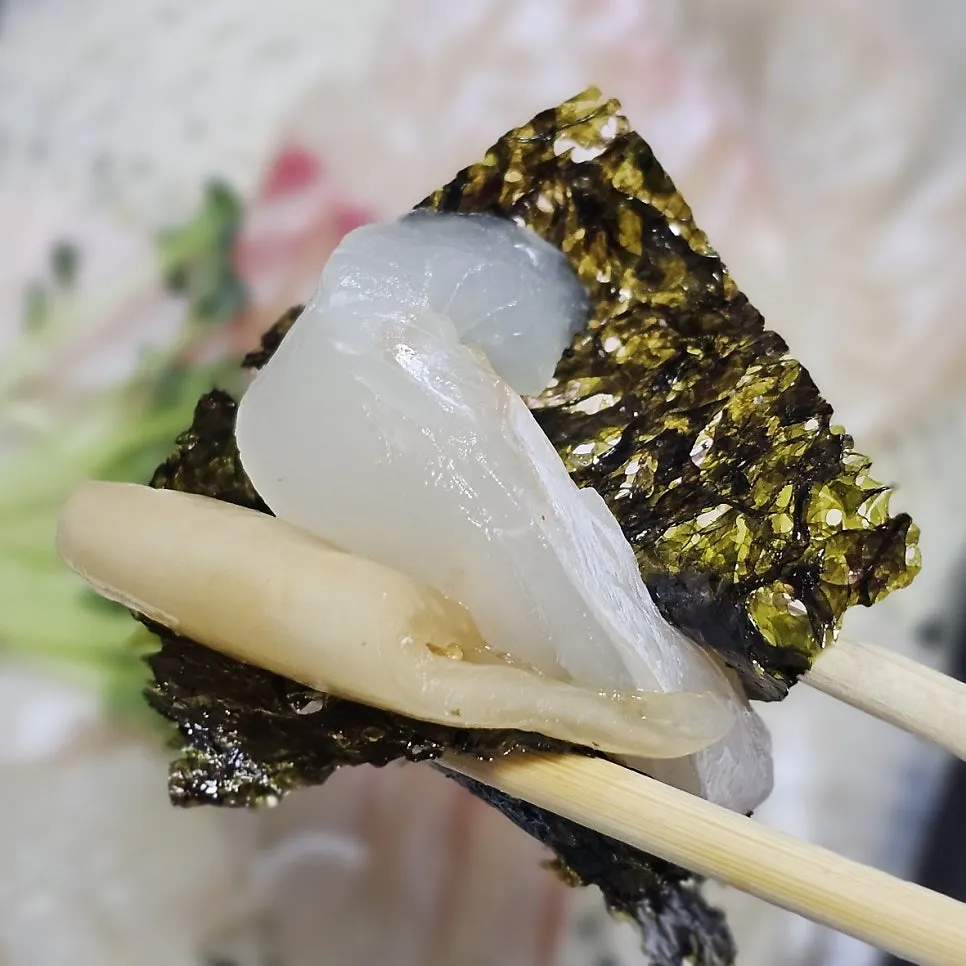 A bite-sized wrap of vinegared rice and live shrimp