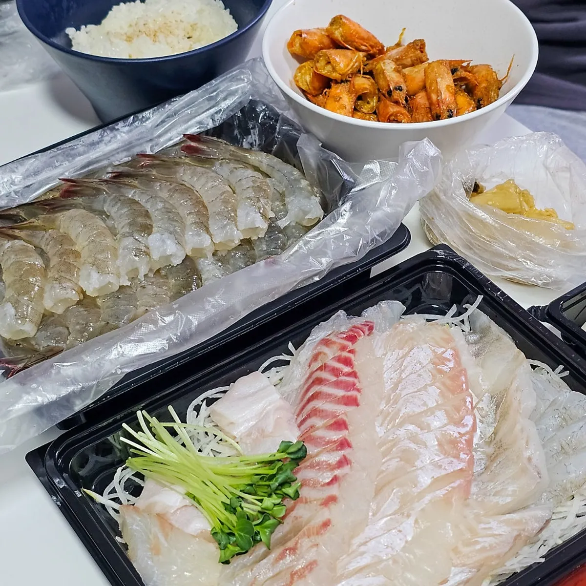 Table of sashimi and live shrimp enjoyed by 4 people at home