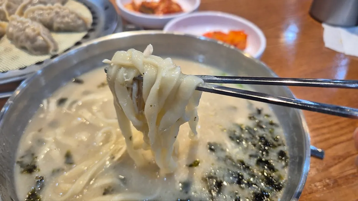 Chicken kalguksu topped with laver and chicken meat