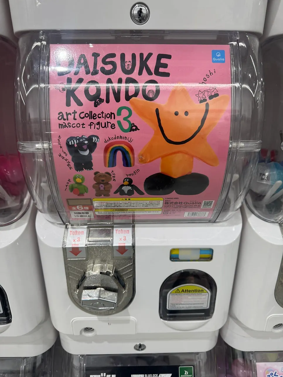 Child spinning a gachapon capsule toy machine
