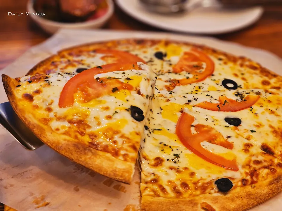 A slice of margherita pizza with melted mozzarella cheese