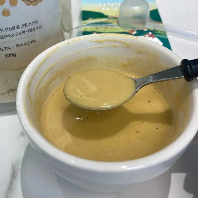A cup of cream soup topped with nuts