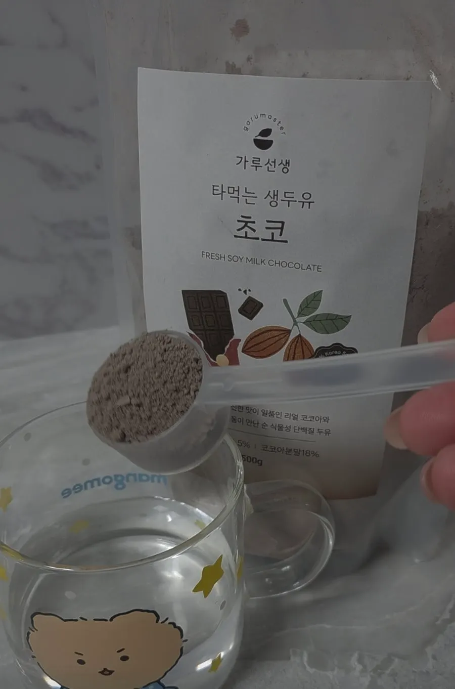 컵에 담긴 초코 두유 가루와 계량 스푼