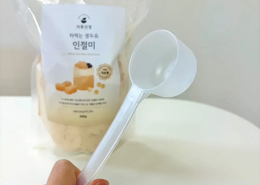 Scooping out the injeolmi soy milk powder with the included spoon