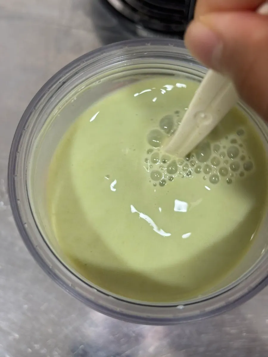 A cup of matcha soy milk mixed with cold water