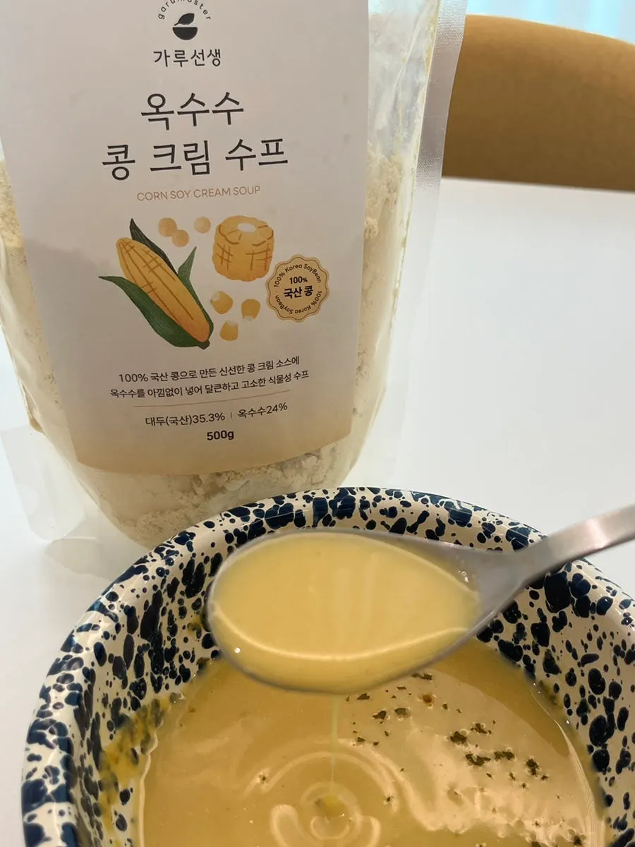 Spoonful of corn cream soup lifted from the bowl