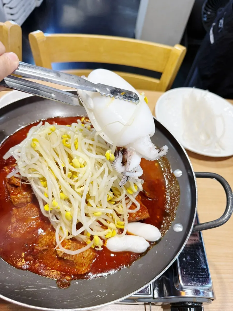 A pot of spicy braised short ribs topped with plump cuttlefish