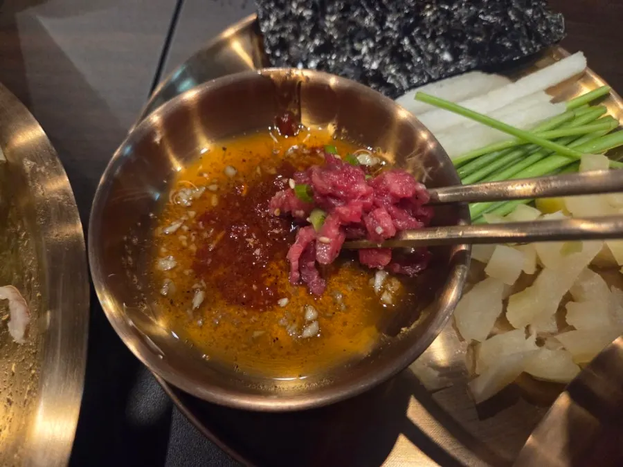 A bite of yukhoe wrapped in seaweed
