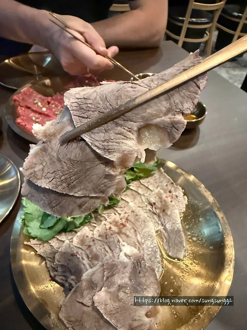접시수육 한 점을 집어 든 모습