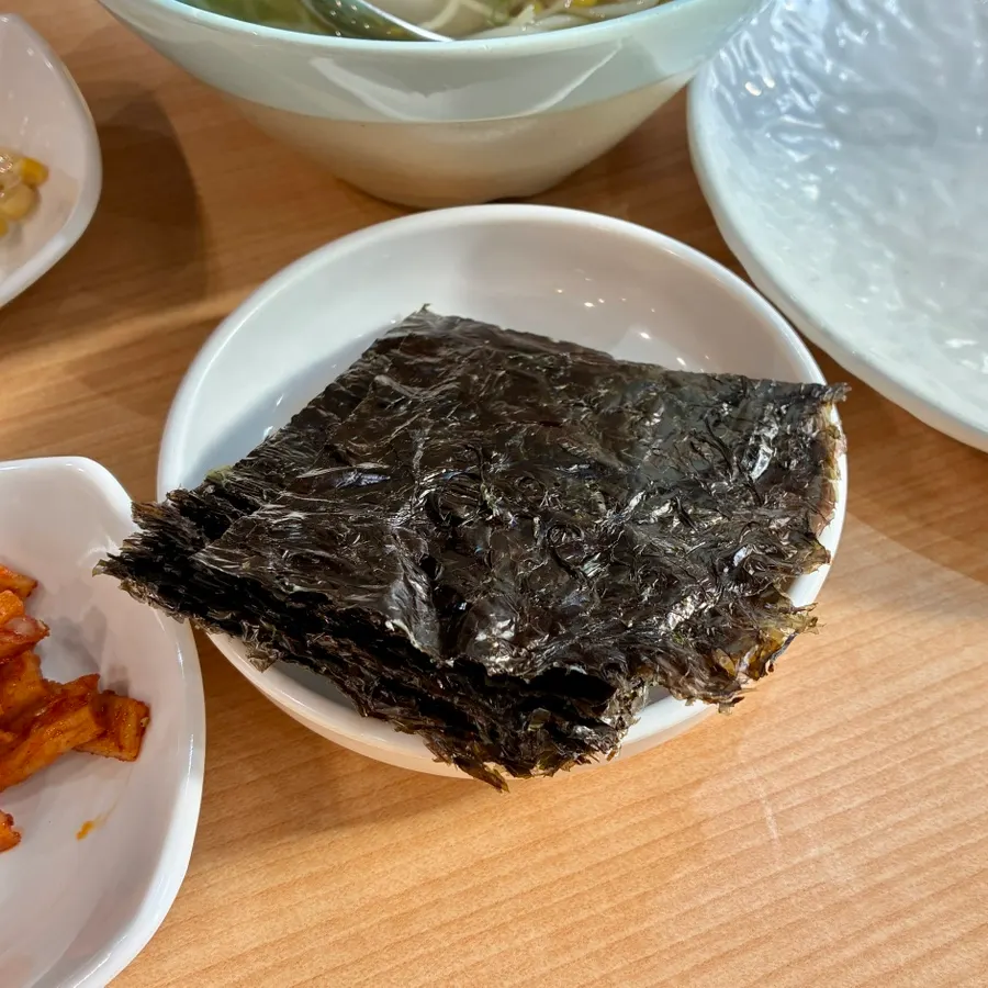 A bite of braised short ribs with glass noodles and bean sprouts