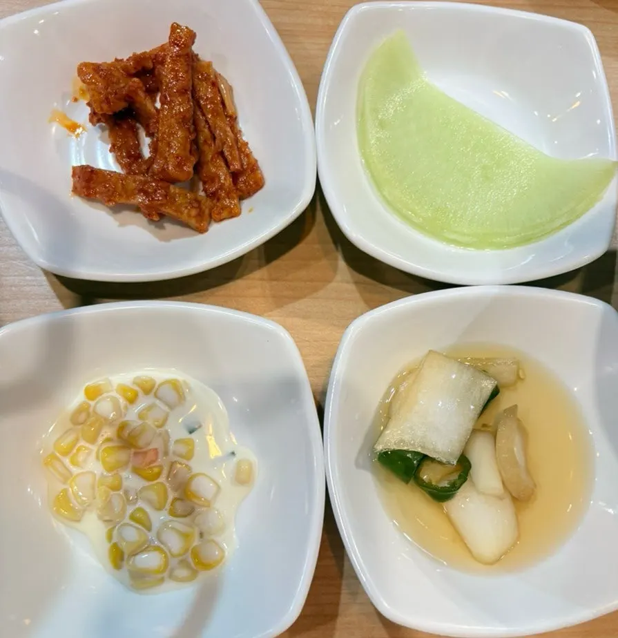 A spread of basic side dishes including corn salad and kimchi