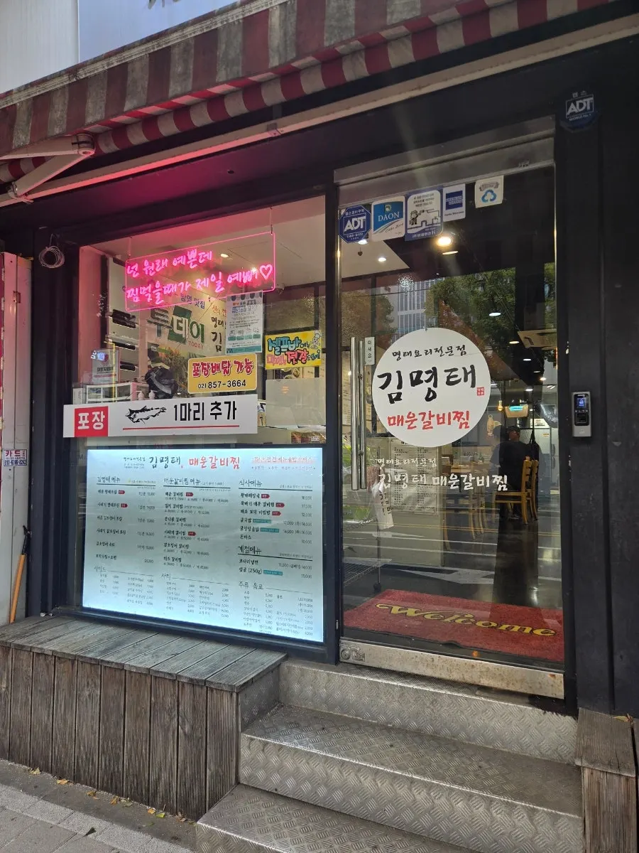 Large menu board at the entrance and floor-to-ceiling glass exterior