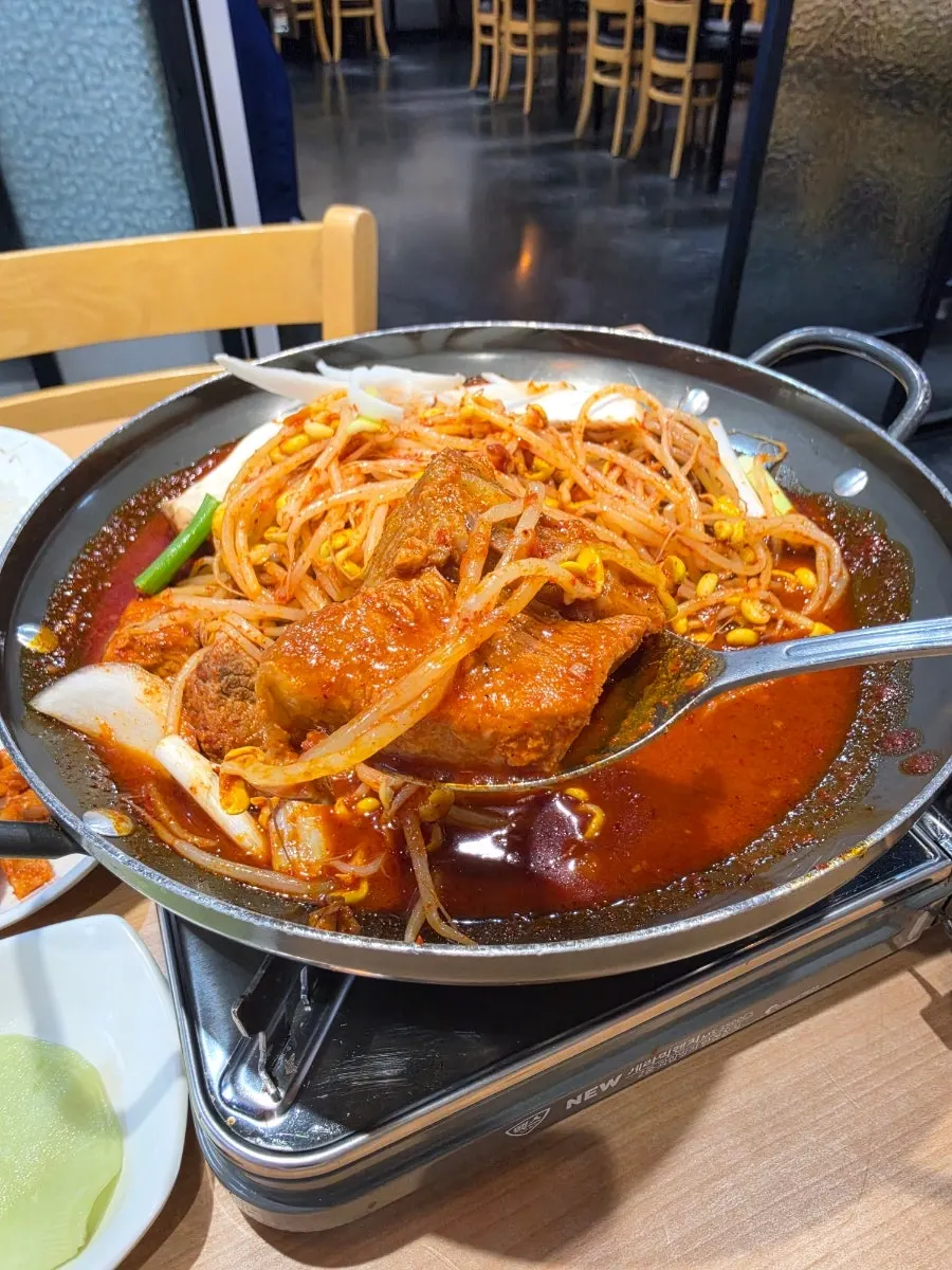 Pan of spicy braised ribs bubbling at the table